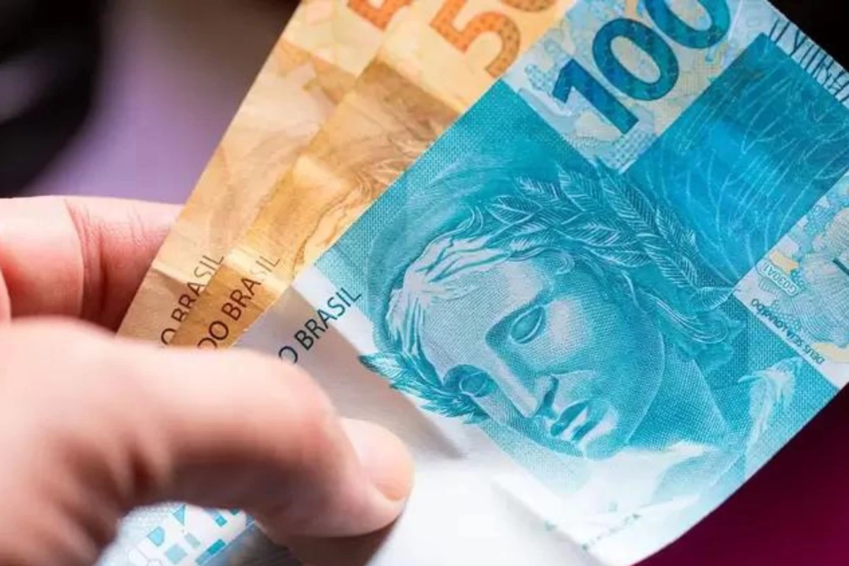 Infográfico mostra cédulas de real e a projeção do salário mínimo 2027 em destaque